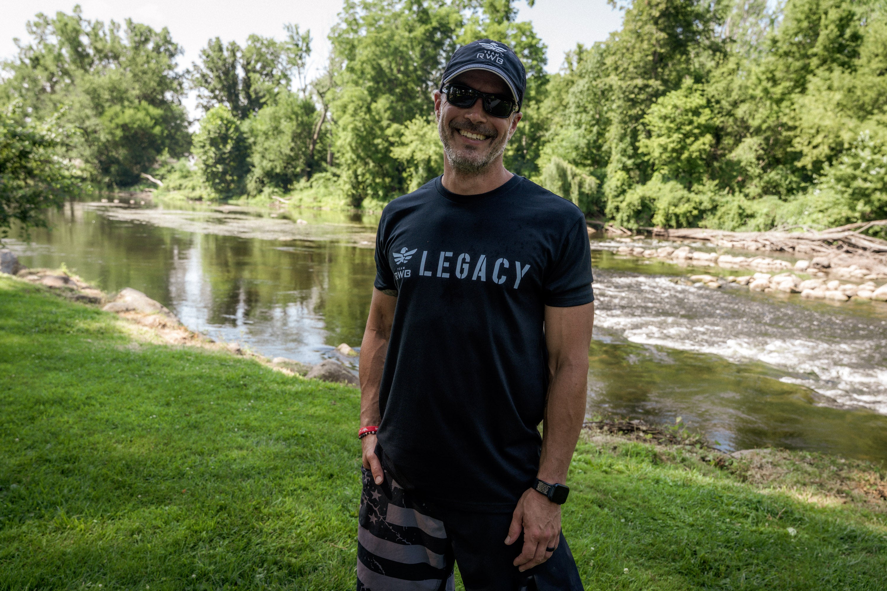Man wearing Team RWB Legacy anniversary shirt at an outdoor event, front view showing graphic