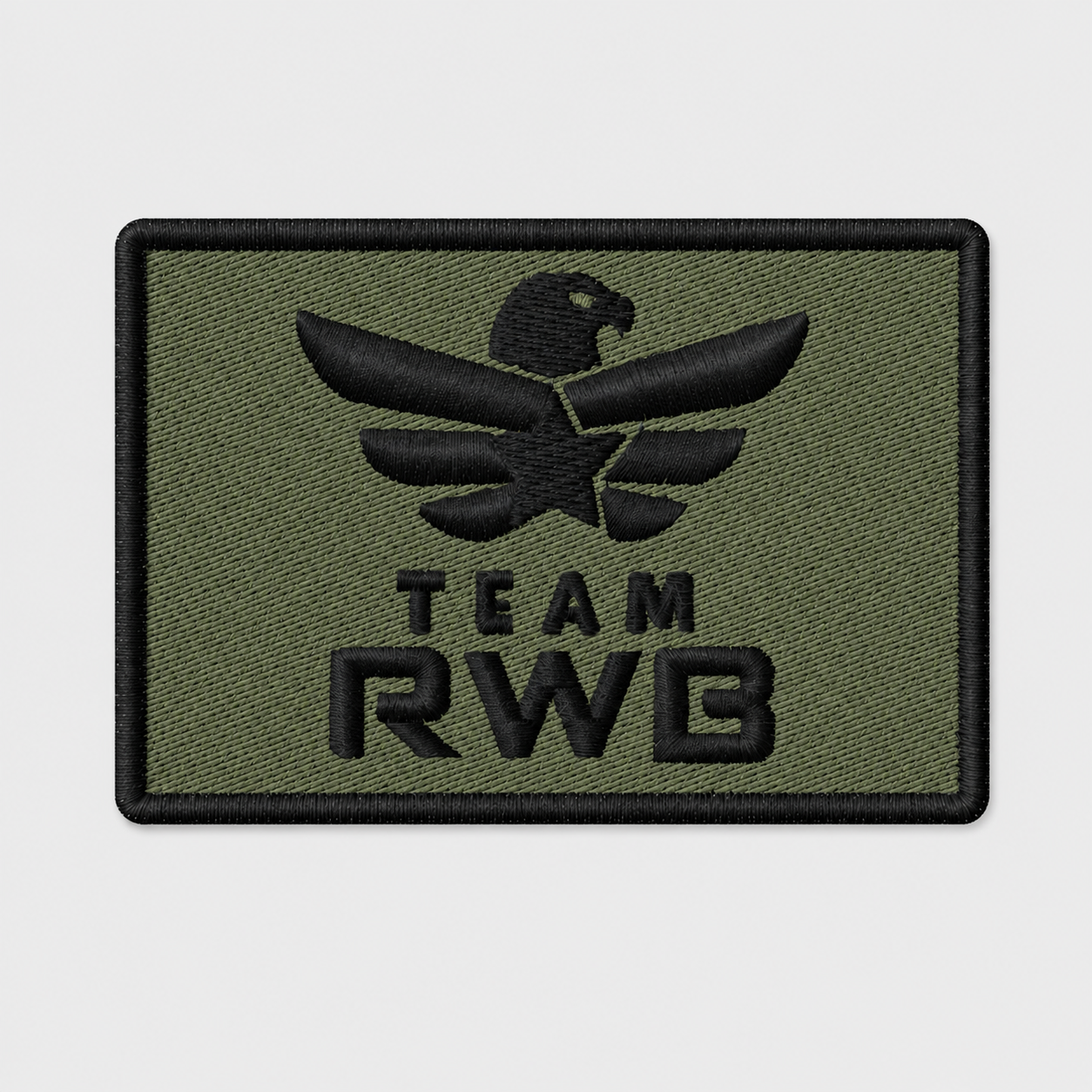 Team RWB Velcro Patch Logo Subdued Tactical, low-visibility embroidered Eagle on tactical-color background, 2x3 inch hook-backed morale patch, flat lay