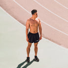 Man in black athletic shorts standing on a track