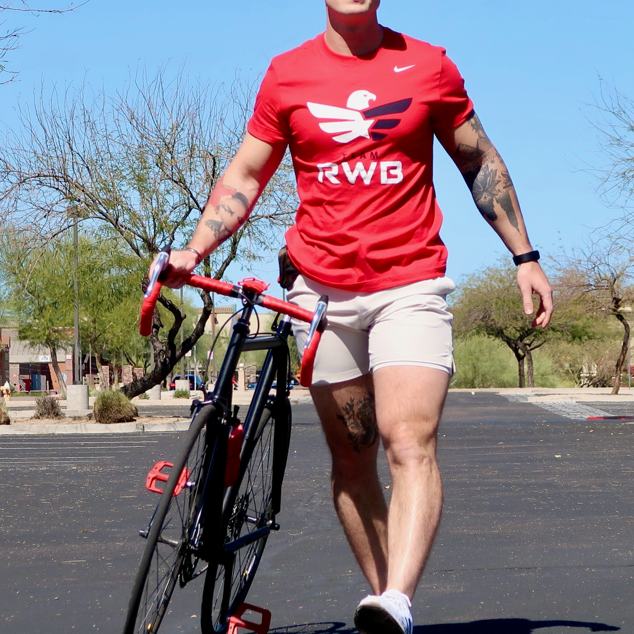 Team RWB member walking with bicycle in Men's Nike Dri-FIT T-Shirt
