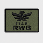 Team RWB Velcro Patch Logo Subdued Tactical, low-visibility embroidered Eagle on tactical-color background, 2x3 inch hook-backed morale patch, flat lay