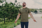 Man holding a jump rope on a path with trees in the background